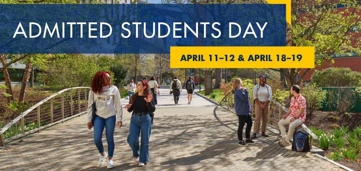 students on campus walking across a bridge during spring season